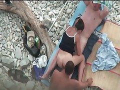 Couple fucks on the beach as a stud watches
